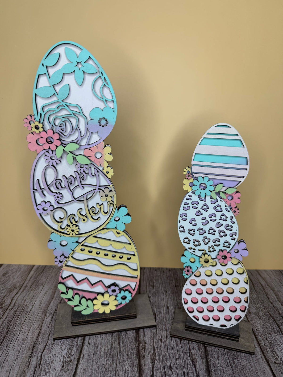 A colorful 3D layered egg decoration with multiple intricate patterns and the text 'Happy Easter' displayed on one of the eggs.