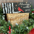 A lighted sign with a cardinal bird design, surrounded by Christmas decorations like lights and ornaments.