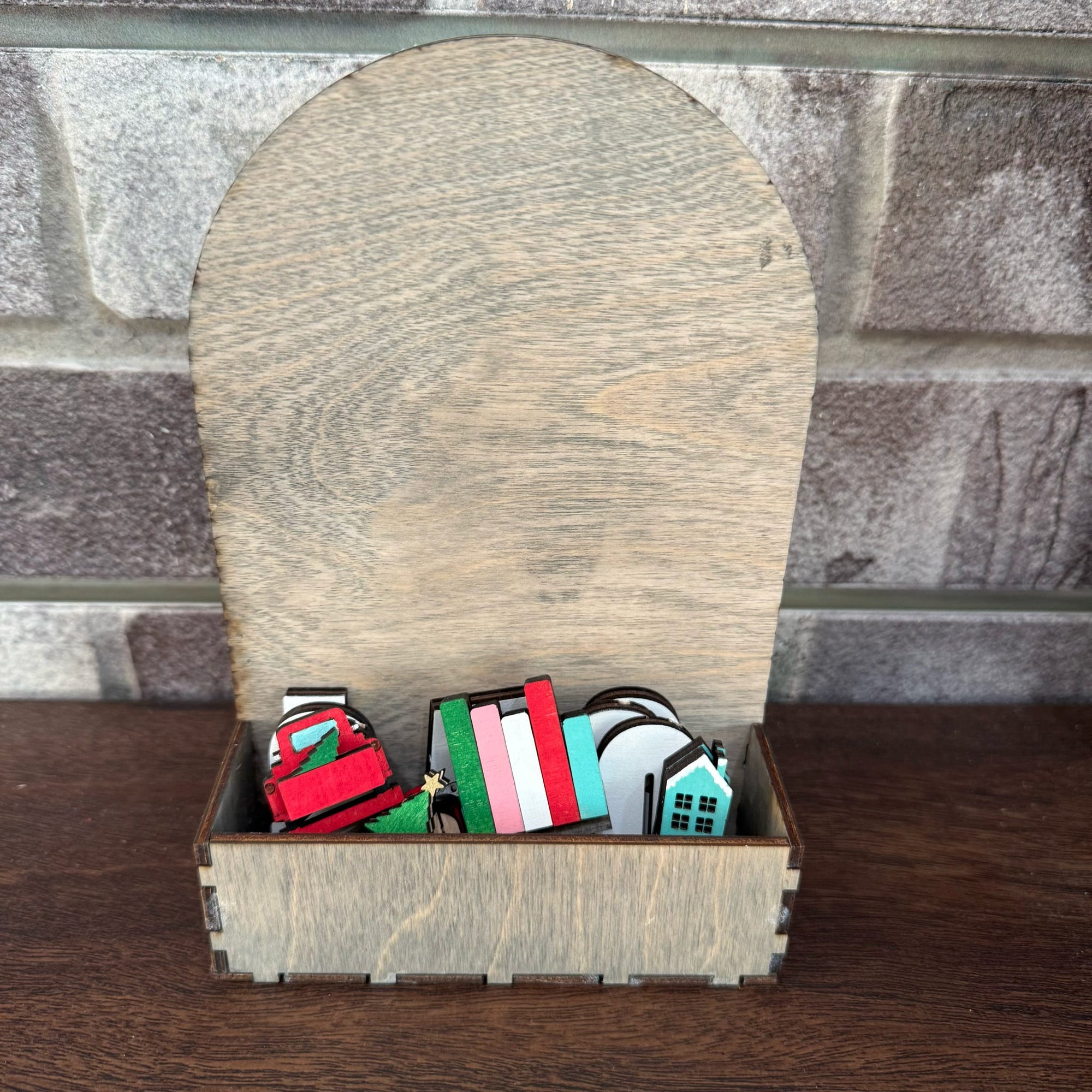 Wooden box with small decorative items on a wooden surface and stone wall background