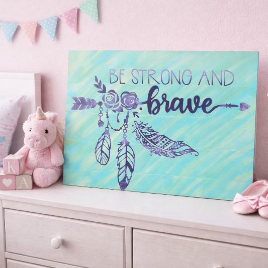 Children's room with motivational sign 'Be Strong and Brave', pink decor, and unicorn plush toy.