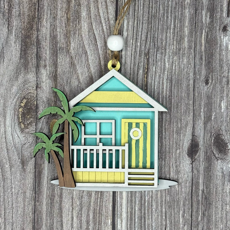 Decorative ornament of a beach house with a palm tree on a wooden background