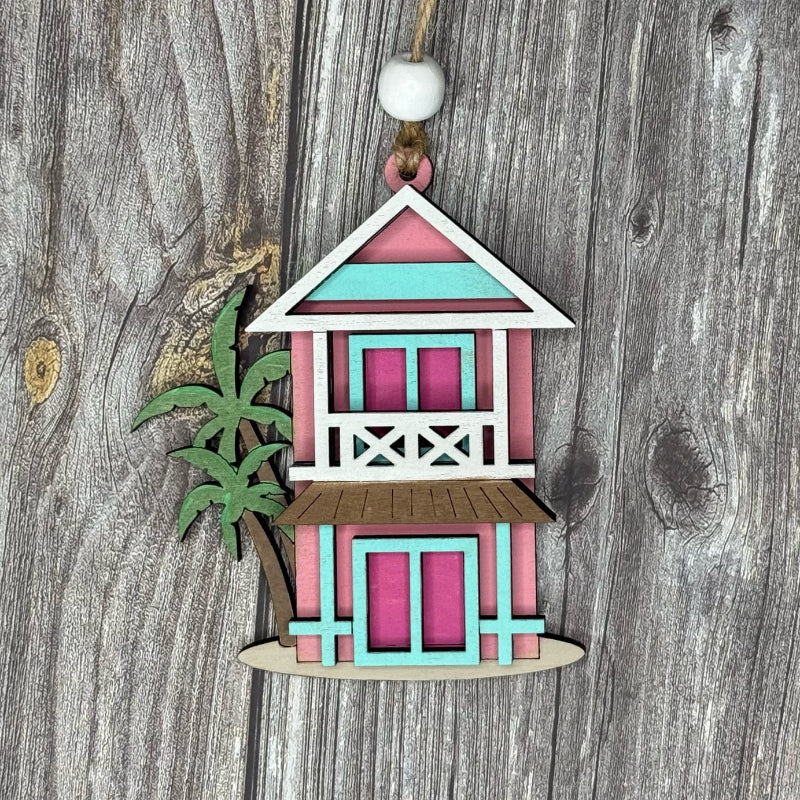 Decorative miniature hut with a green plant on a wooden background