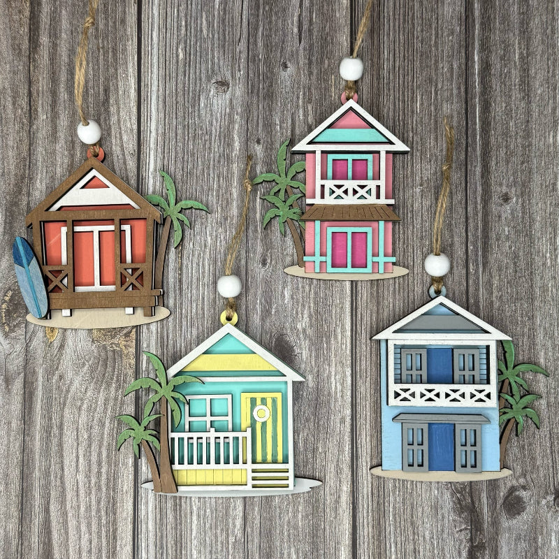 Set of four colorful beach house ornaments on a wooden background