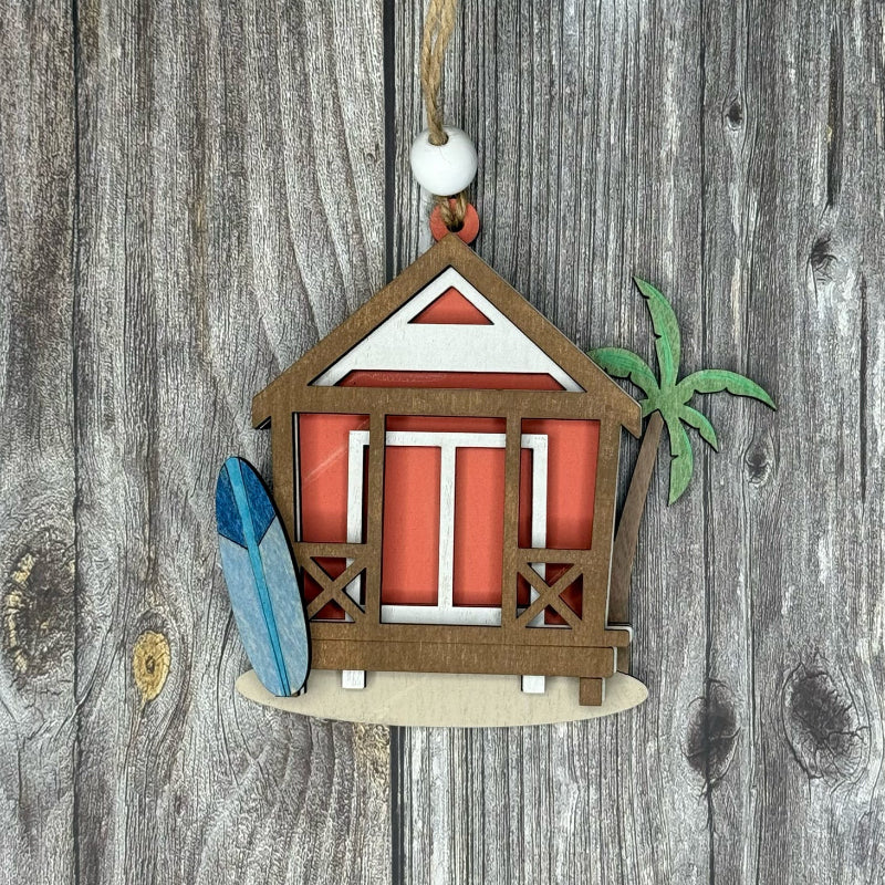 Decorative ornament of a beach hut with a palm tree and surfboard on a wooden background