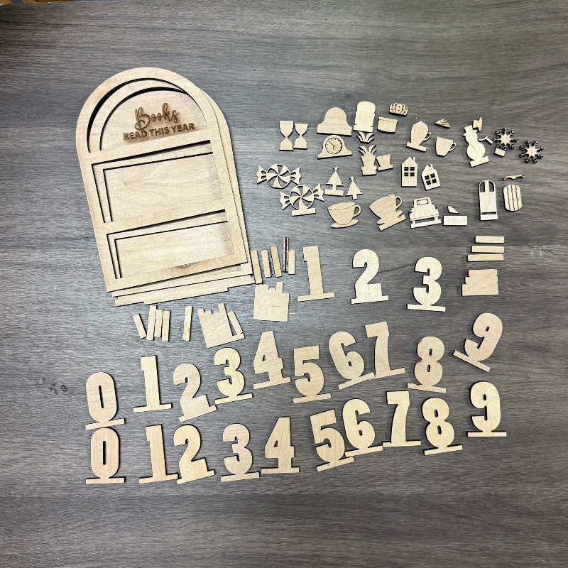 Wooden cutouts of a door, numbers, and various shapes on a wooden surface