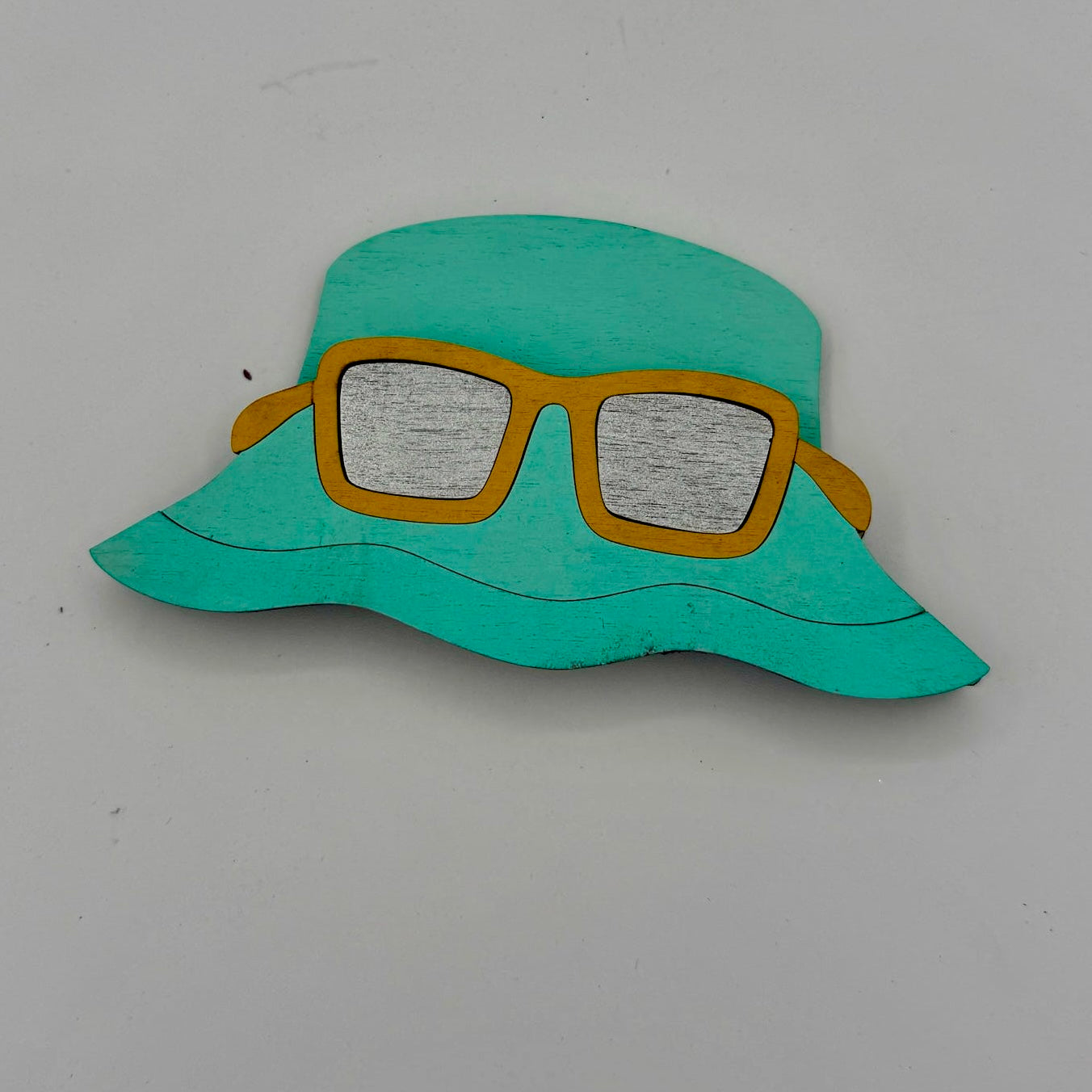Turquoise hat with yellow sunglasses on a white background