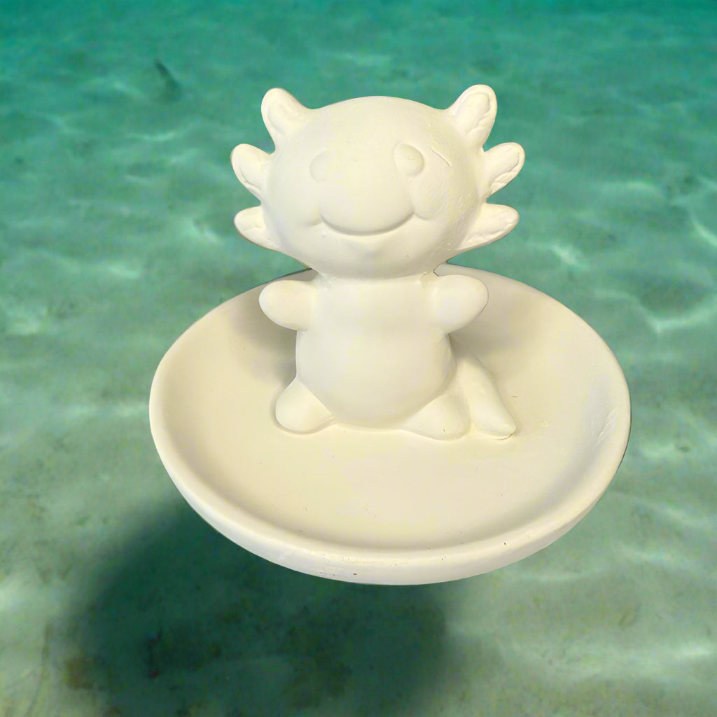 White ceramic dragon figurine on a round white plate against a wooden background
