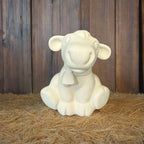 White ceramic lamb figurine on a wooden surface with a rustic background