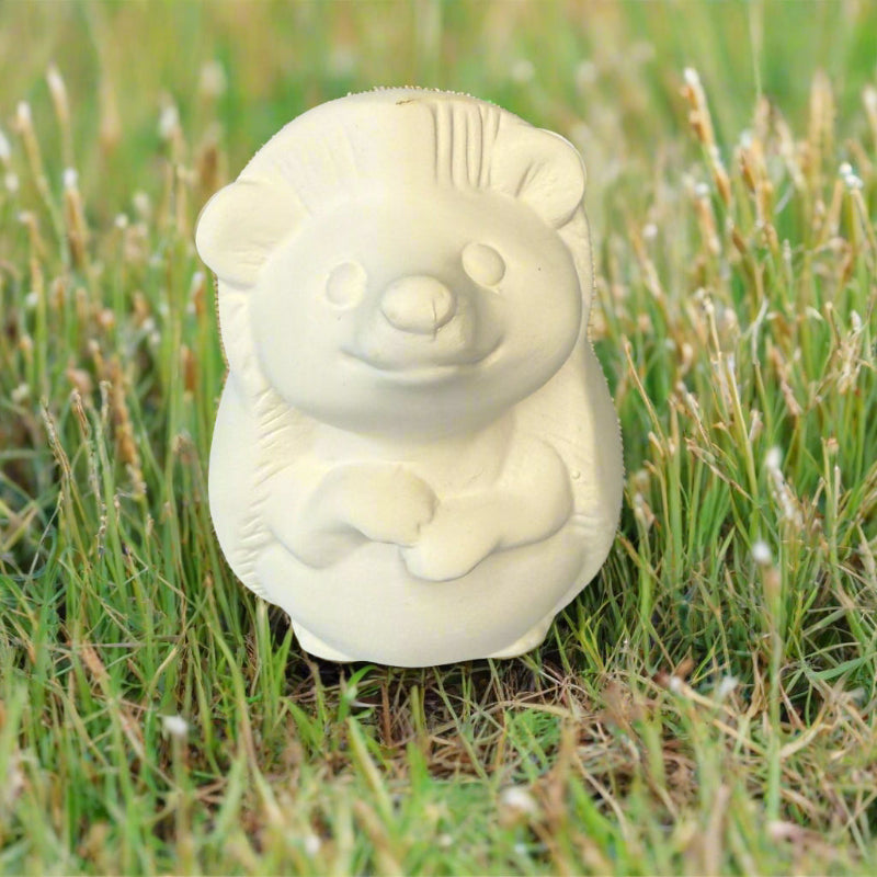 White ceramic bear-shaped object on a wooden surface
