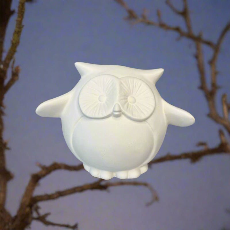 White owl-shaped container on a wooden surface