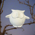 White owl-shaped container on a wooden surface