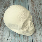Decorative skull with intricate designs on a wooden surface