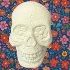 White ceramic skull with decorative patterns on a wooden surface