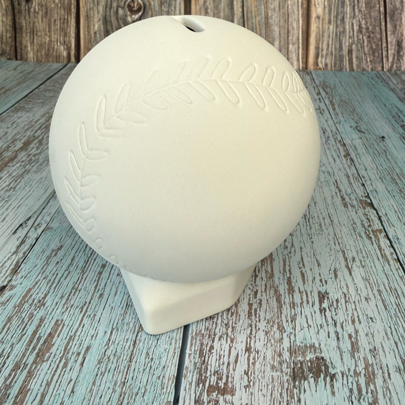 White ceramic ball with embossed design on a wooden surface