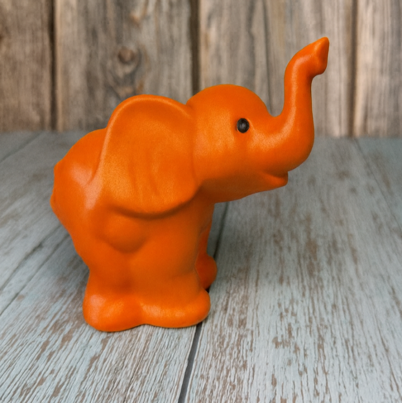 Orange elephant figurine on a wooden surface