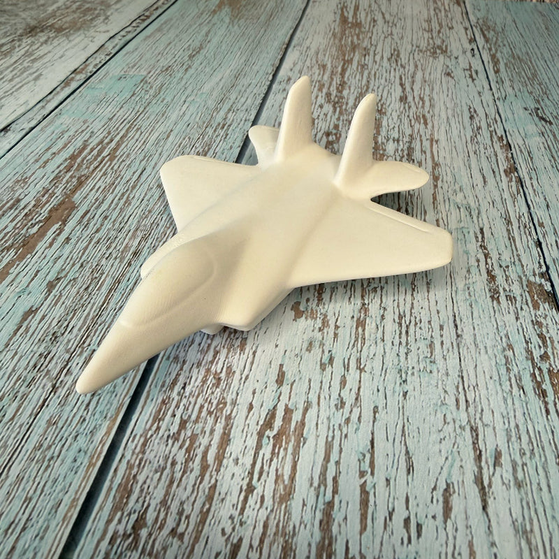 White model of a fighter jet on a wooden surface
