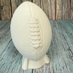 White textured football on a stand against a wooden background