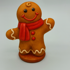 Gingerbread man figurine with a red scarf on a gray background