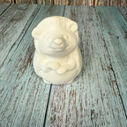 White ceramic bear-shaped object on a wooden surface