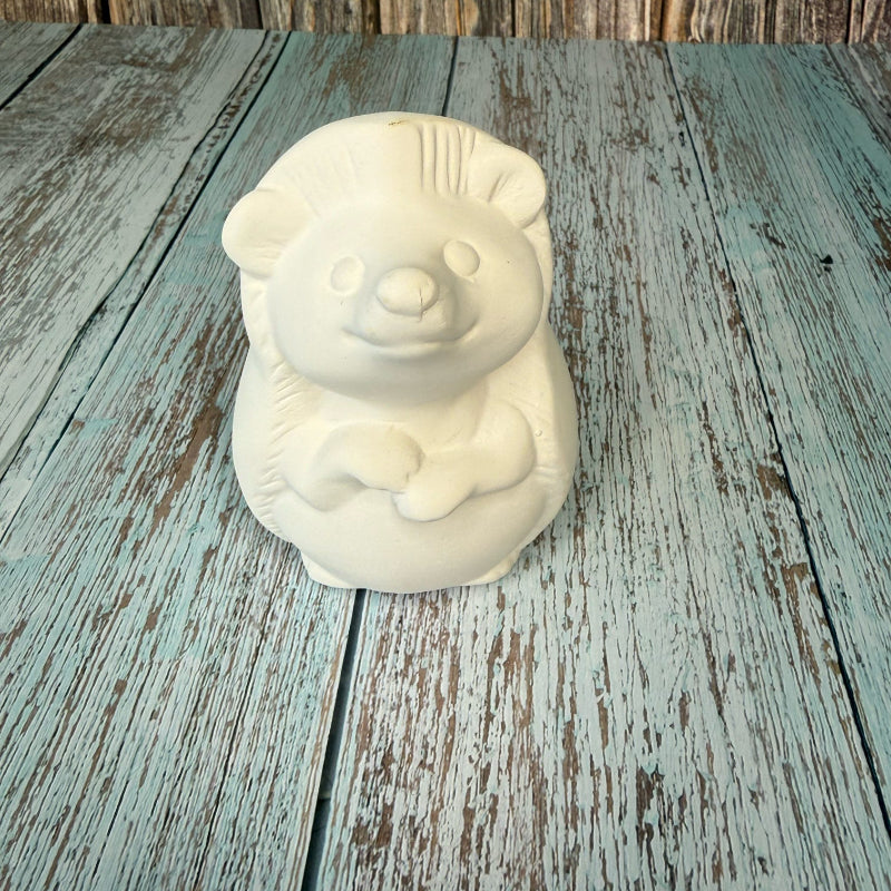 White ceramic bear-shaped object on a wooden surface