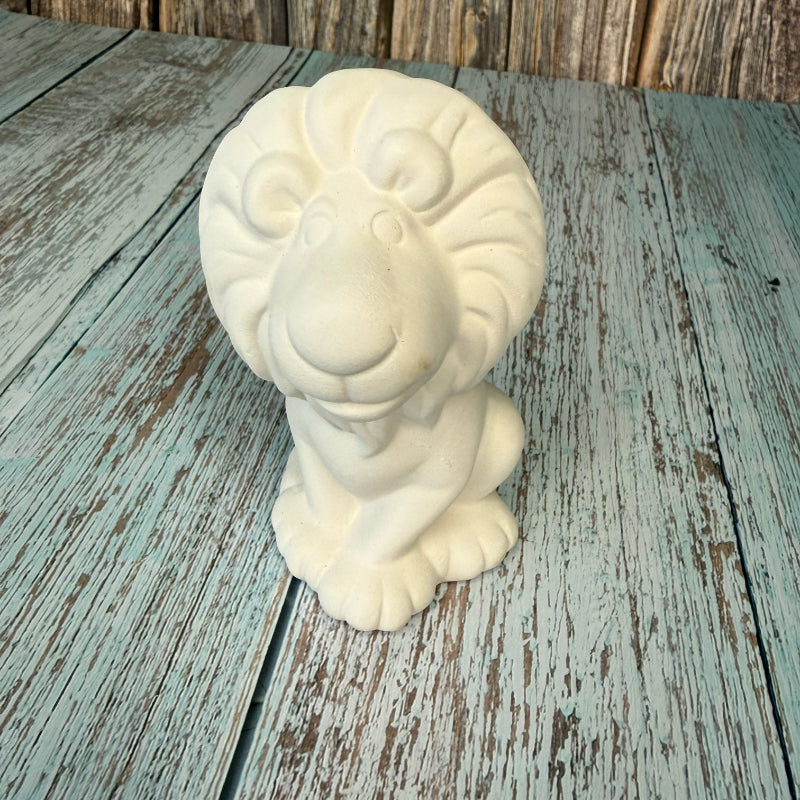 White ceramic ram head sculpture on a wooden surface