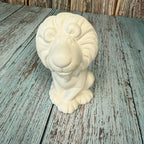 White ceramic ram head sculpture on a wooden surface