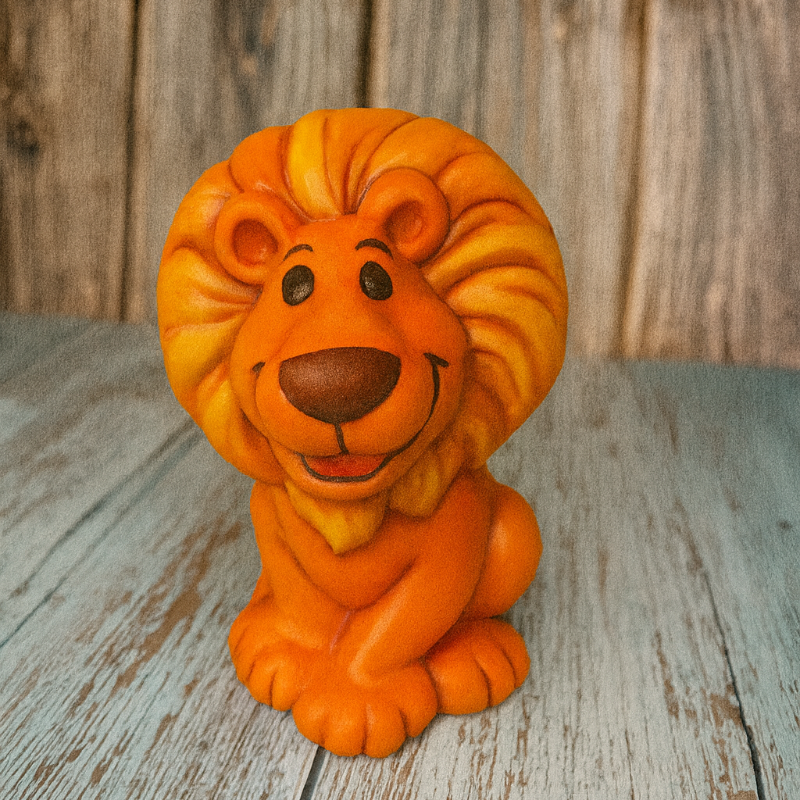 Orange lion figurine on a wooden surface with a rustic background