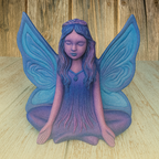 Decorative figurine of a fairy with blue wings on a wooden surface