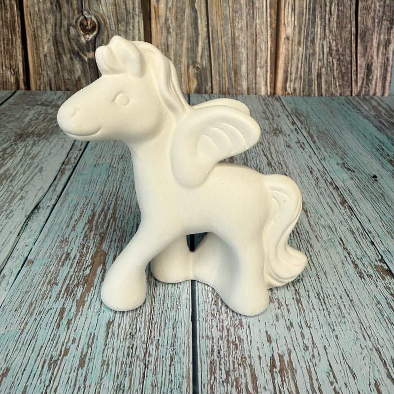 White ceramic unicorn figurine on a wooden surface