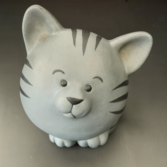 Ceramic cat-shaped container on a gray background