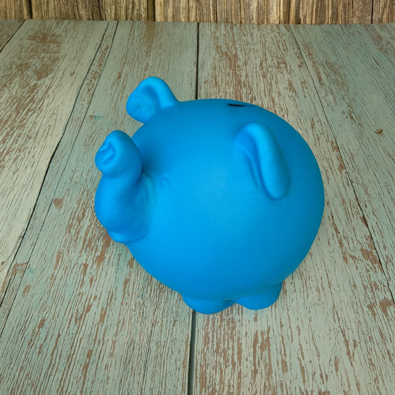 Blue pig-shaped container on a wooden surface