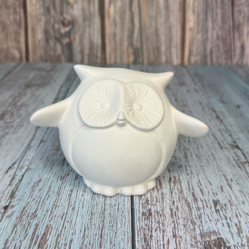 White owl-shaped container on a wooden surface