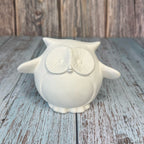 White owl-shaped container on a wooden surface