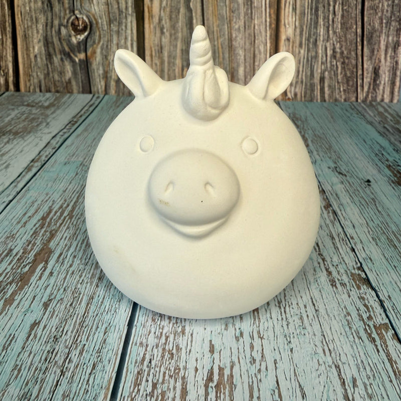 White unicorn-shaped object on a wooden surface