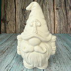 Unpainted ceramic gnome figurine on a wooden surface