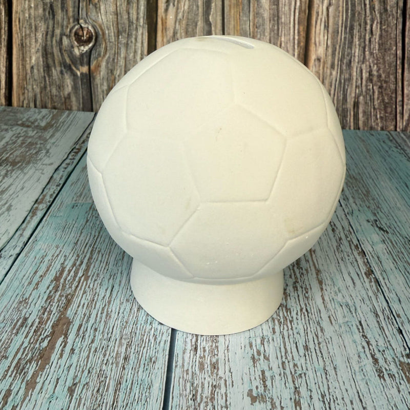 White soccer ball on a rustic wooden surface