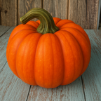 Orange pumpkin on a wooden surface with a wooden wall background