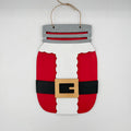 A Santa Claus-themed mason jar hanging ornament made from painted wood, featuring red body sections, a white vertical section, a black belt, a tan buckle, and a gray top with twine hanger.