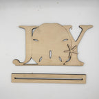 A natural wood decorative sign shaped like the word 'JOY' with a starfish detail, shown above a matching wooden mounting strip on a plain white background.