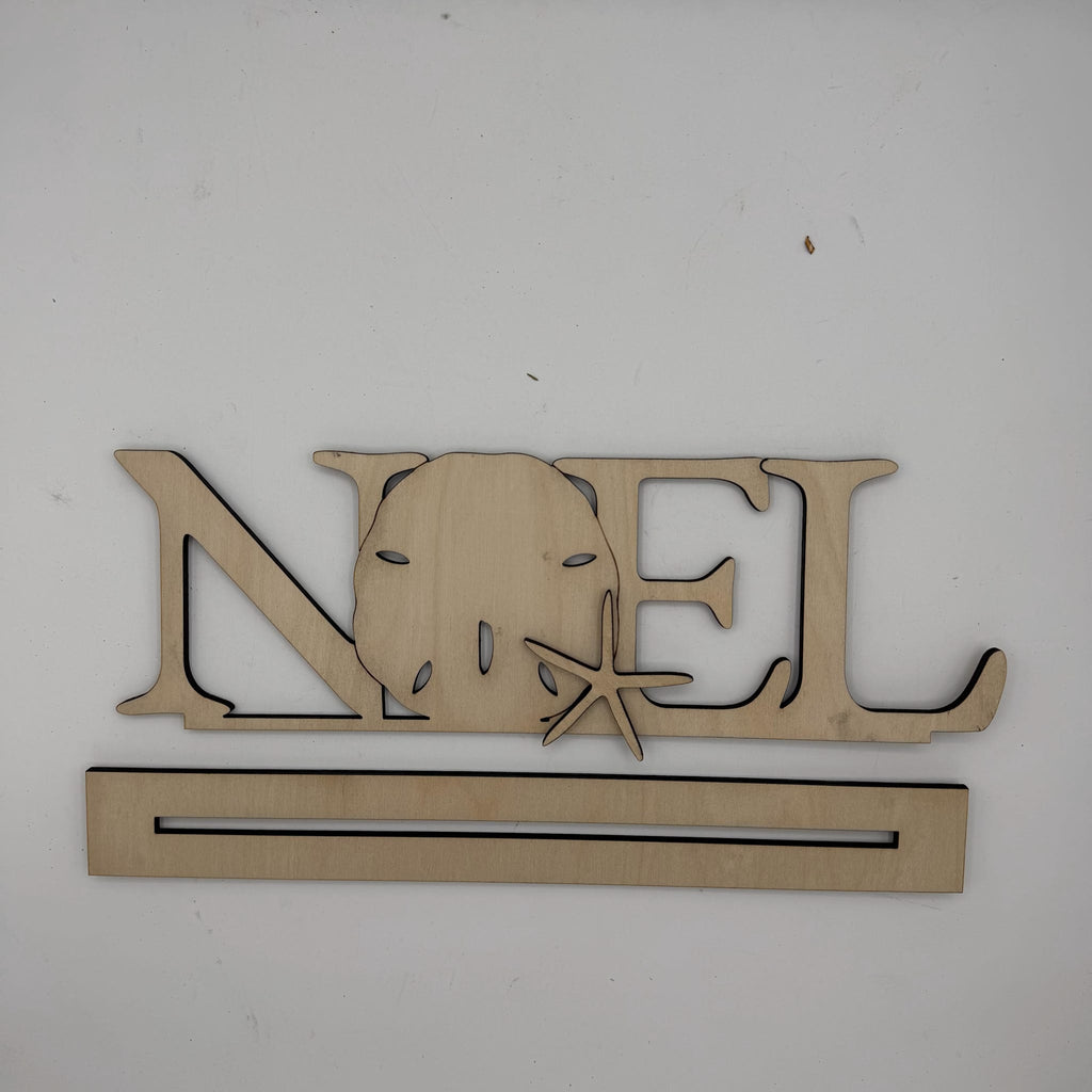A wooden personalized name sign spelling 'NOEL' with a sand dollar and starfish cutout, mounted on a plain white wall above a long rectangular wooden base.