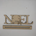 A wooden personalized name sign spelling 'NOEL' with a sand dollar and starfish cutout, mounted on a plain white wall above a long rectangular wooden base.