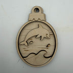 A laser-cut wooden ornament or plaque featuring a dolphin jumping over stylized waves, shown on a plain off-white background.