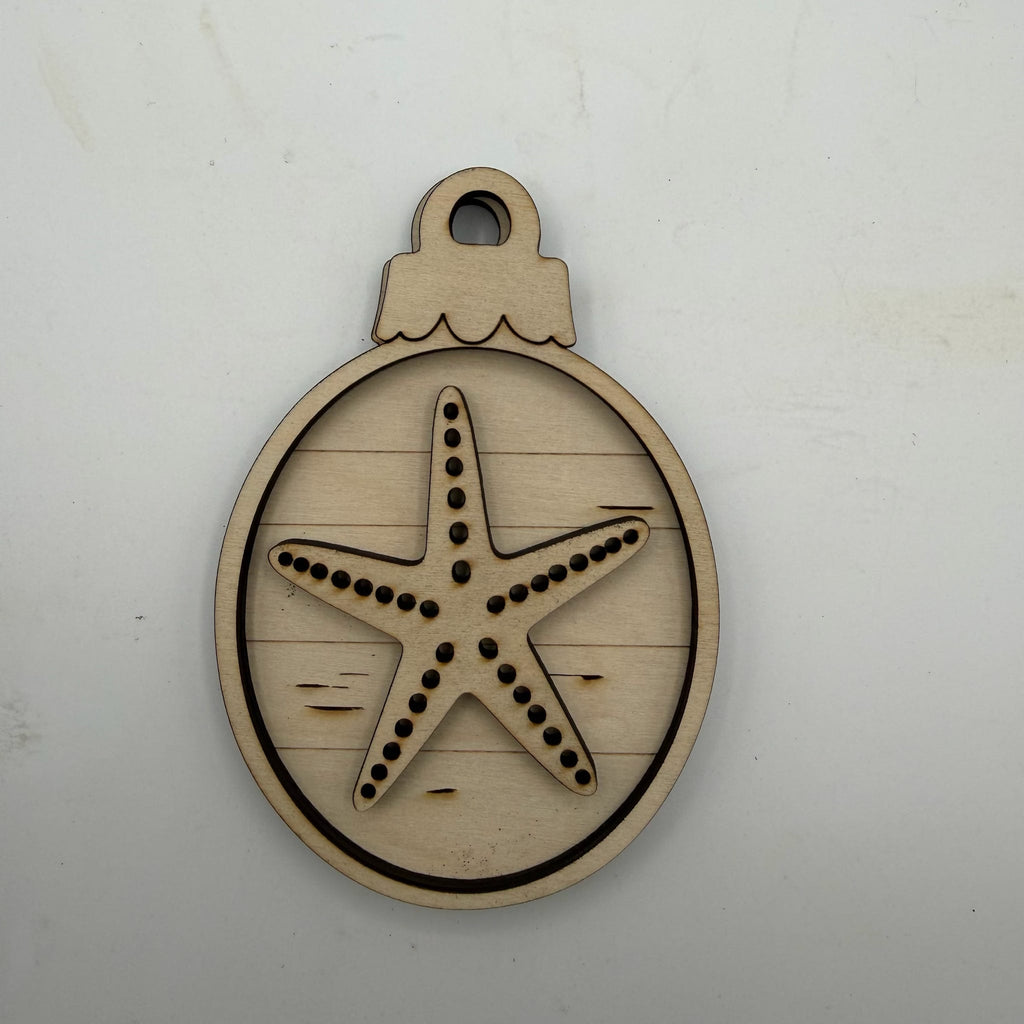 A laser-cut wooden ornament-shaped tag or charm featuring a starfish design, shown on a plain off-white background.