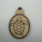 A laser-cut wooden ornament or plaque featuring a sea turtle design inside an oval frame with a hanging loop at the top, shown on a plain light background.