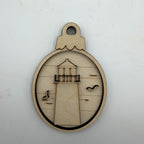 A circular laser-cut wooden ornament featuring a lighthouse design with cutout birds, displayed on a plain white background.