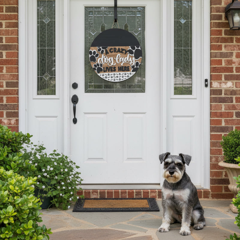 Decorative sign with 'A crazy dog lady lives here' text and paw prints on a door.