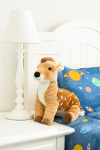 Plush deer toy on a nightstand next to a child's bed with space-themed bedding