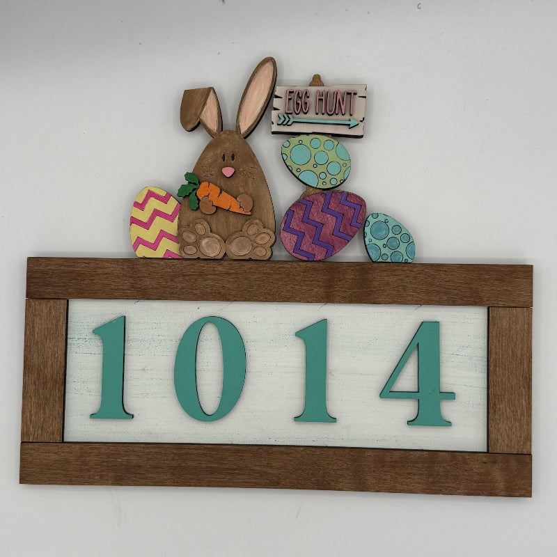Decorative house number sign with a rabbit and Easter eggs on a white background