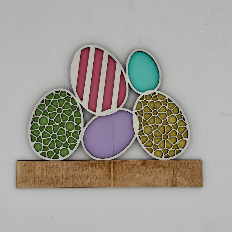 Decorative wall art with colorful circular patterns on a wooden base against a light gray background