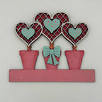 Decorative wall art with hearts and a bow on a white background